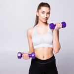 portrait-of-pretty-sporty-woman-holding-weights-isolated-on-white-wall